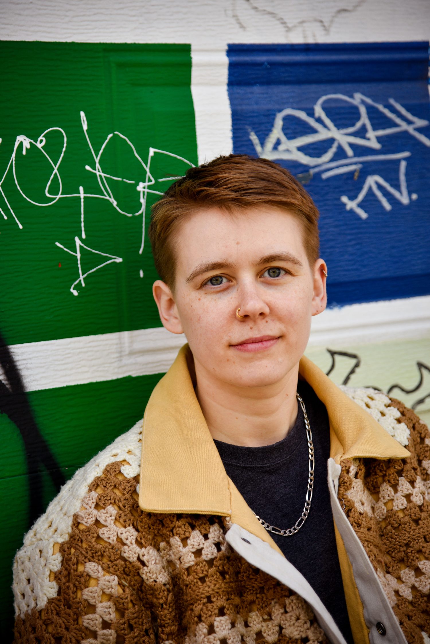Filip standing in front of a green and blue painted wall.